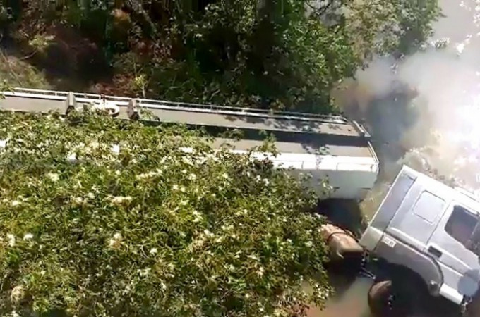 Itpolis: Carreta-tanque cai em ribanceira e fica dentro de rio 